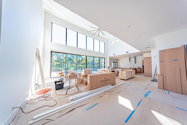 living room featuring a high ceiling and ceiling fan