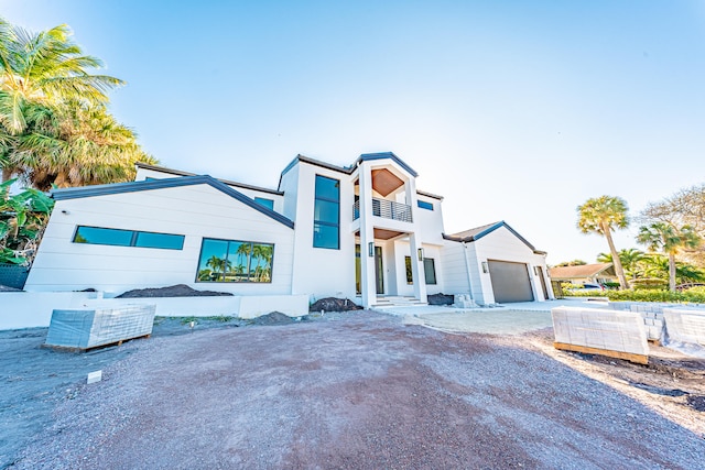 view of front of property featuring a balcony and a garage