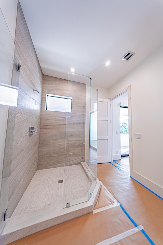 bathroom featuring tiled shower and a healthy amount of sunlight