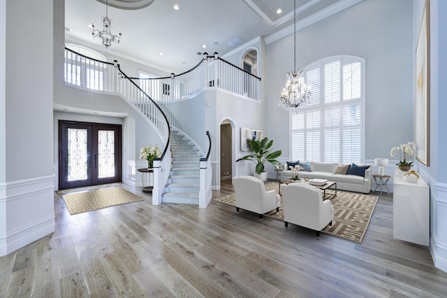 entryway featuring light hardwood / wood-style flooring, a high ceiling, and french doors