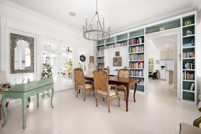 3645 Ocean Dr, Vero Beach, FL 32963 - dining area featuring ornamental molding, french doors, a chandelier, built in features, and light wood-type flooring