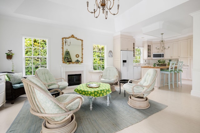 living room featuring a tray ceiling, light hardwood / wood-style floors, and a notable chandelier