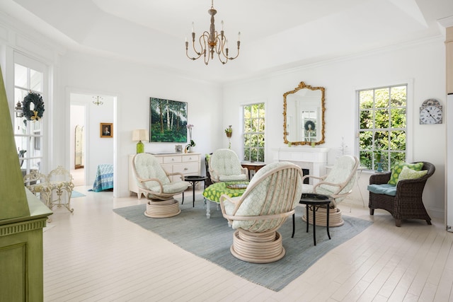 3645 Ocean Dr, Vero Beach, FL 32963 - living room featuring a chandelier, wood finished floors, crown molding, a fireplace, and a raised ceiling