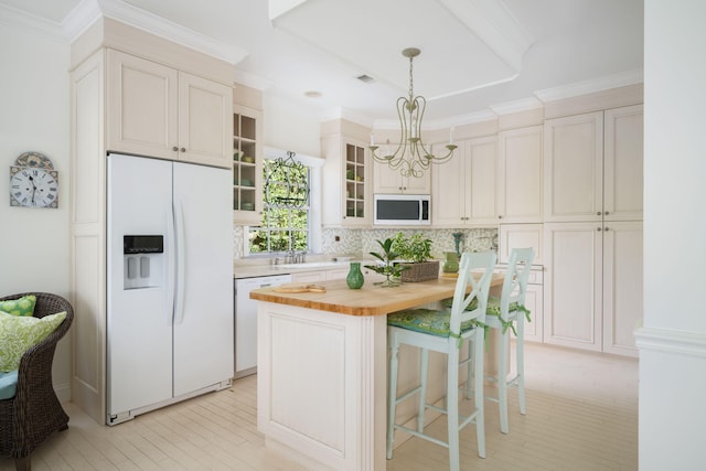 3645 Ocean Dr, Vero Beach, FL 32963 - kitchen featuring white appliances, wooden counters, a chandelier, a kitchen island, and glass insert cabinets