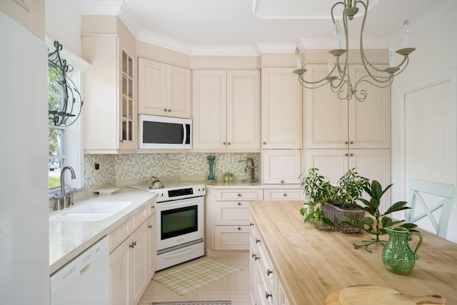 3645 Ocean Dr, Vero Beach, FL 32963 - kitchen with white appliances, butcher block countertops, decorative backsplash, crown molding, and glass insert cabinets