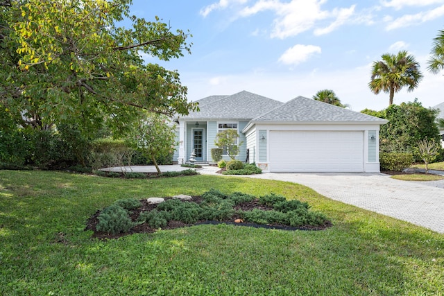 3645 Ocean Dr, Vero Beach, FL 32963 - view of front of home featuring a garage, decorative driveway, a front lawn, and roof with shingles