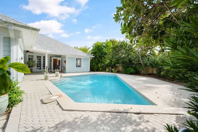 view of swimming pool featuring a patio area, ceiling fan, and french doors