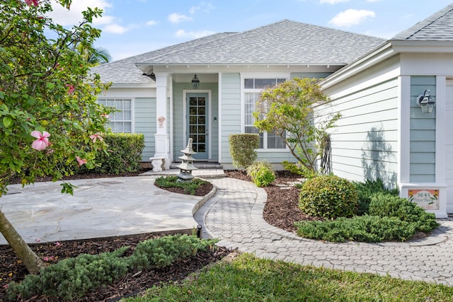 3645 Ocean Dr, Vero Beach, FL 32963 - doorway to property featuring a shingled roof and a patio