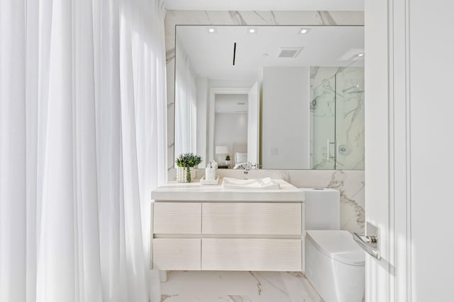 bathroom featuring vanity, toilet, a shower with shower door, and tile walls