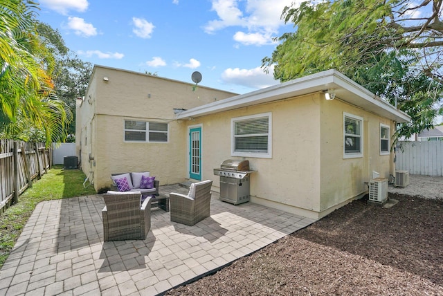 back of property with central AC, a patio, and an outdoor hangout area