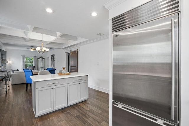 kitchen featuring dark hardwood / wood-style flooring, stainless steel built in fridge, decorative light fixtures, and coffered ceiling