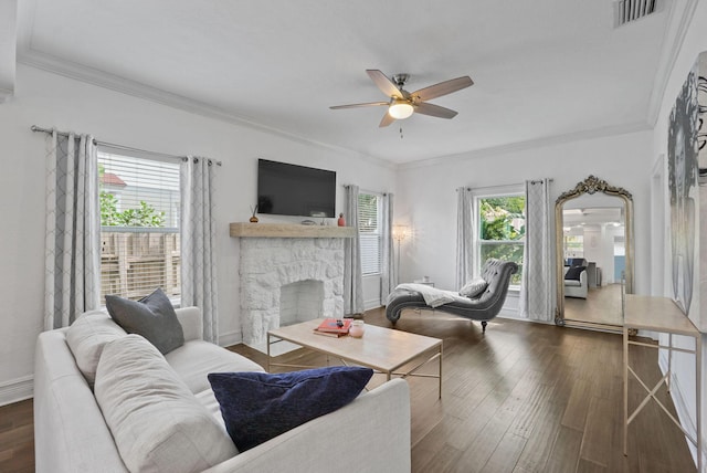 living room featuring a fireplace, ornamental molding, dark wood-type flooring, and a wealth of natural light