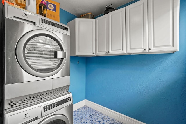 laundry room featuring cabinets and stacked washer and clothes dryer