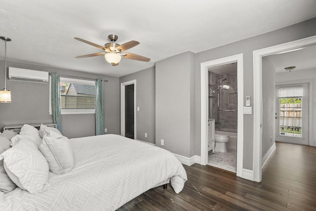 bedroom featuring ensuite bathroom, an AC wall unit, dark hardwood / wood-style floors, and ceiling fan