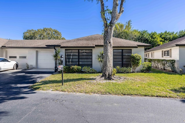 ranch-style home with a front yard and a garage