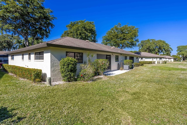 view of front of home with a front lawn and central AC unit