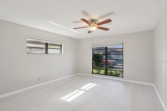 empty room featuring ceiling fan, light hardwood / wood-style flooring, and a textured ceiling