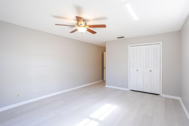 unfurnished bedroom featuring a closet, ceiling fan, and light hardwood / wood-style flooring