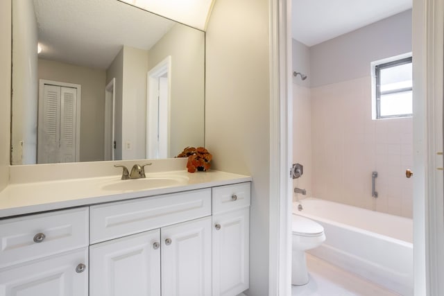 full bathroom featuring a textured ceiling, vanity, toilet, and tiled shower / bath