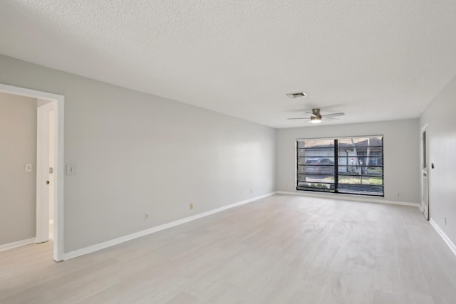 empty room with ceiling fan, a textured ceiling, and light wood-type flooring