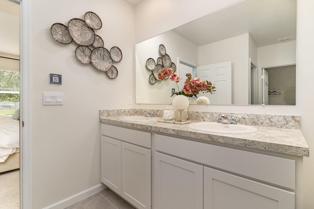 bathroom featuring double vanity, a sink, tile patterned flooring, and connected bathroom