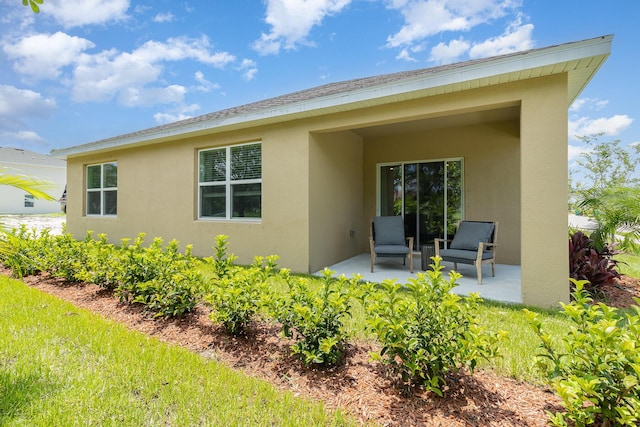 back of house with a patio area and stucco siding