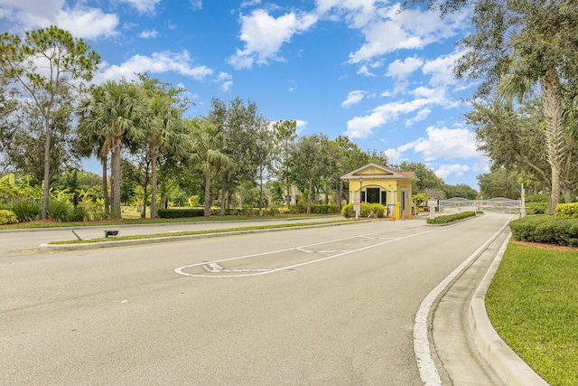 view of street with a gated entry and curbs