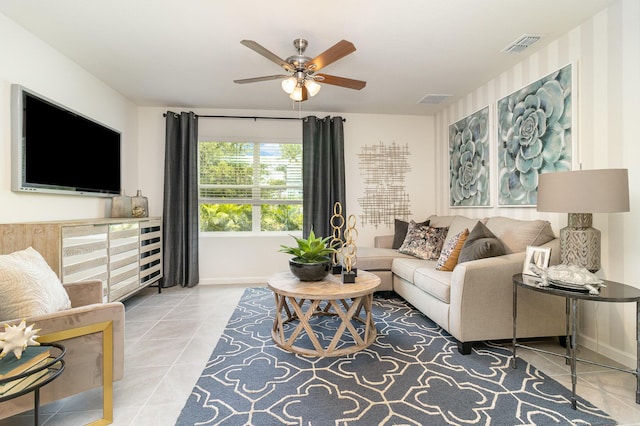 living area featuring tile patterned floors, ceiling fan, baseboards, and visible vents