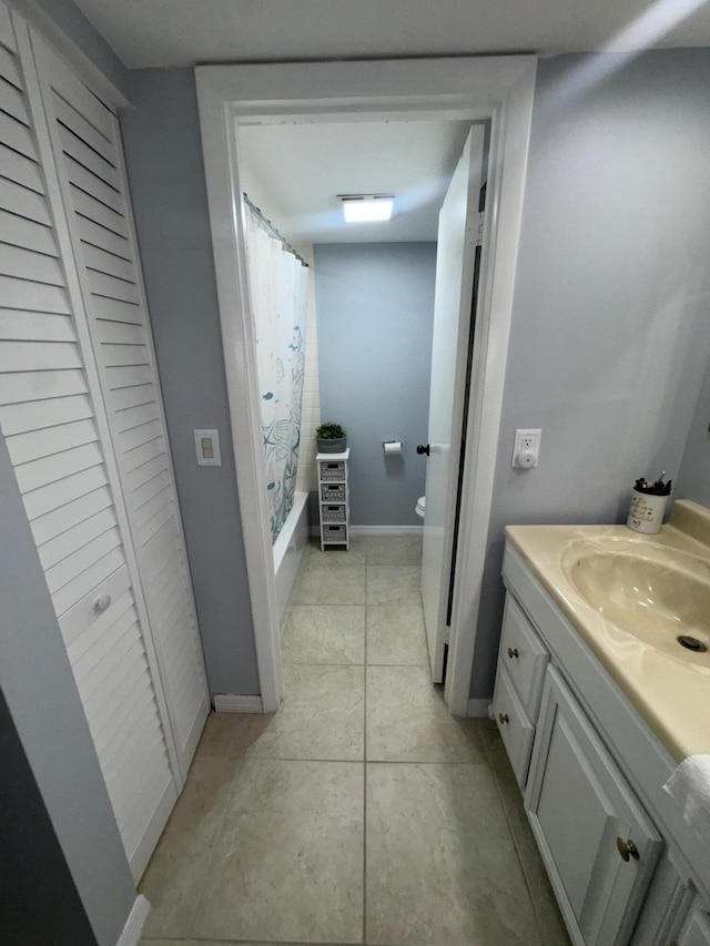 full bathroom featuring shower / bathtub combination with curtain, vanity, toilet, and tile patterned floors