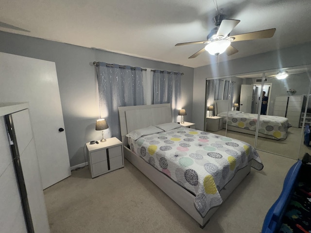 bedroom featuring ceiling fan, a closet, and light carpet