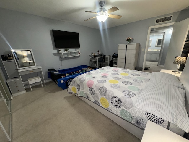 carpeted bedroom with ceiling fan and ensuite bath