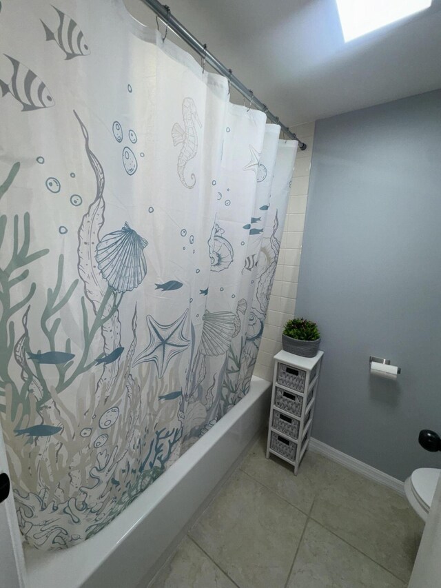 bathroom featuring tile patterned flooring, toilet, and shower / bath combo