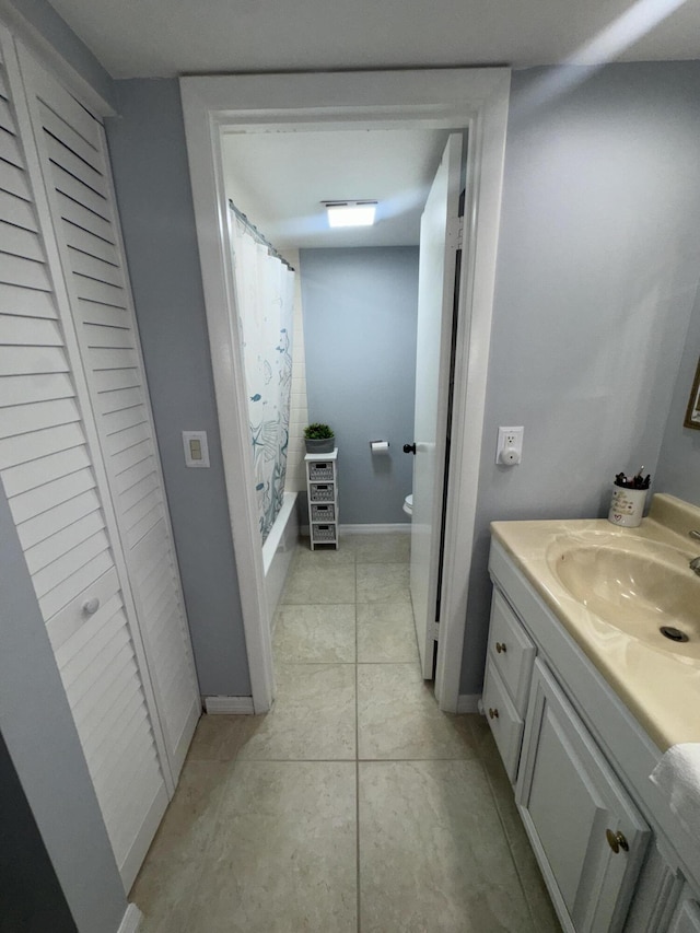 full bathroom with tile patterned flooring, vanity, toilet, and shower / bath combo with shower curtain