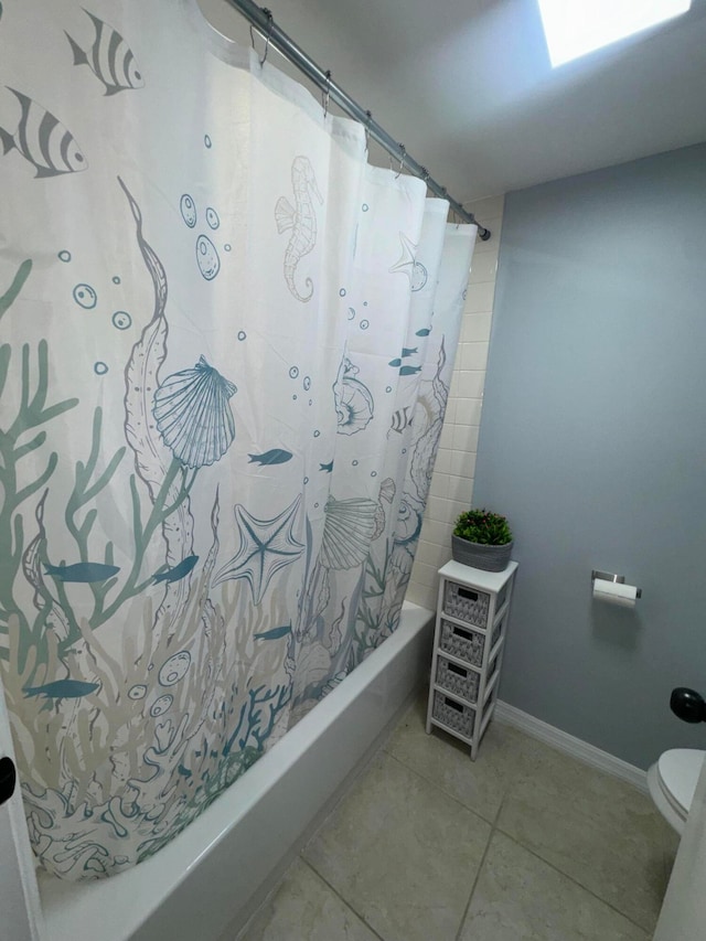 bathroom with tile patterned floors, shower / bath combo with shower curtain, and toilet