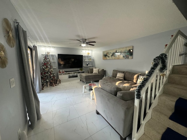 living room with ceiling fan and a textured ceiling