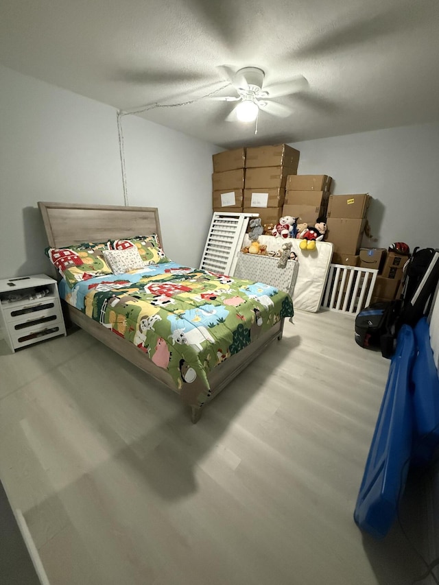 bedroom featuring hardwood / wood-style flooring, a textured ceiling, and ceiling fan