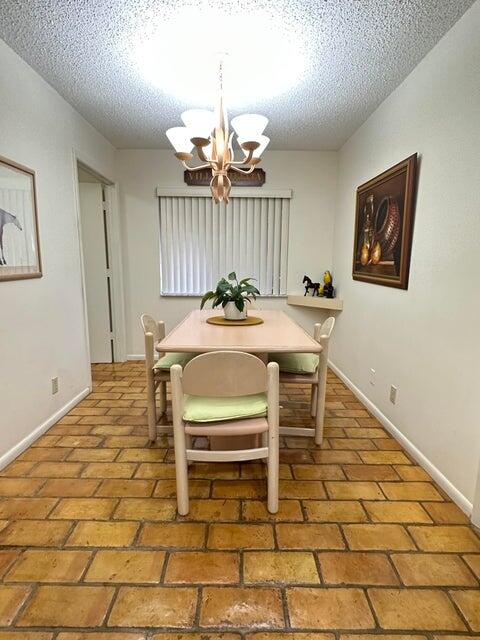 dining area with a textured ceiling and an inviting chandelier