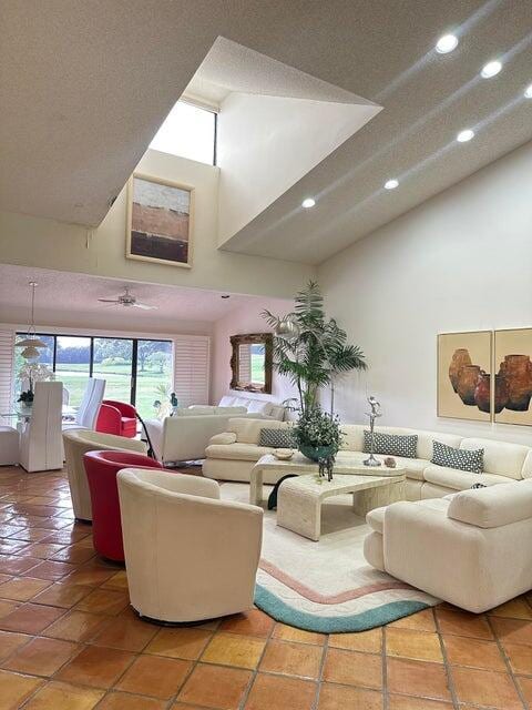 living room with tile patterned flooring, a textured ceiling, and a towering ceiling