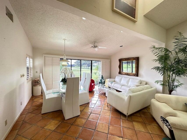 living room with lofted ceiling, ceiling fan, tile patterned floors, and a textured ceiling