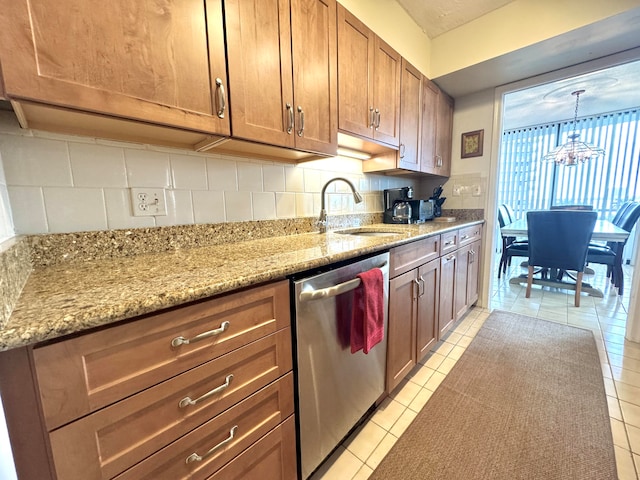 kitchen featuring dishwasher, sink, tasteful backsplash, light tile patterned flooring, and light stone counters