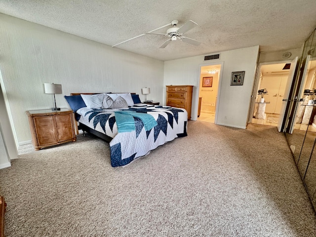 bedroom featuring carpet, ceiling fan, a textured ceiling, and ensuite bath