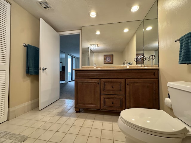 bathroom with tile patterned flooring, vanity, and toilet