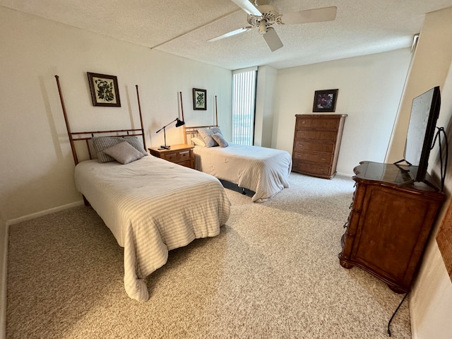 carpeted bedroom featuring ceiling fan and a textured ceiling