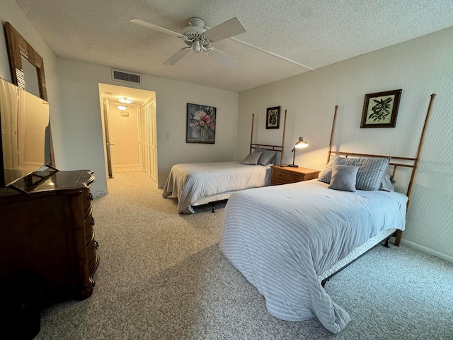 carpeted bedroom featuring a textured ceiling and ceiling fan