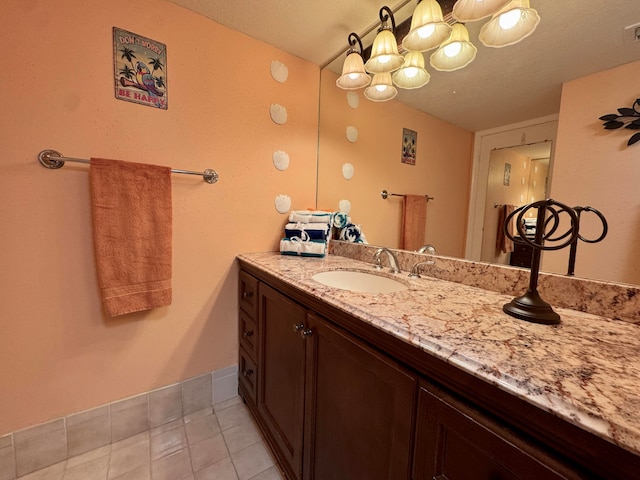 bathroom with a textured ceiling, vanity, and tile patterned floors