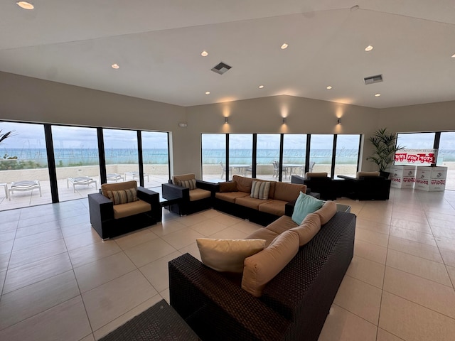 tiled living room with a water view, a wealth of natural light, and lofted ceiling