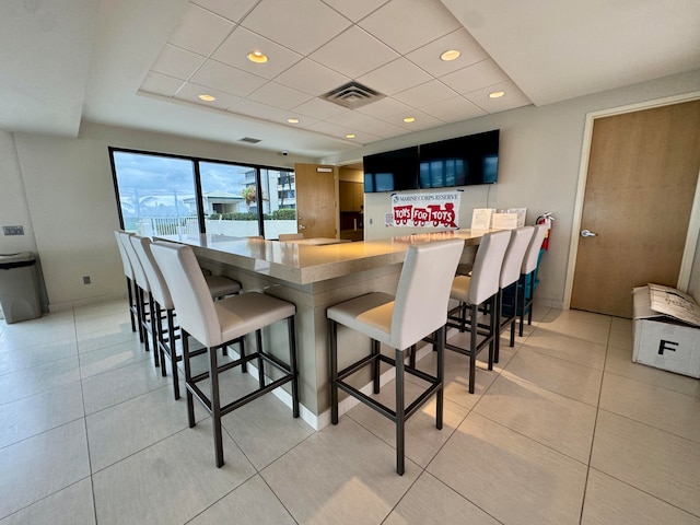 kitchen with a kitchen bar, kitchen peninsula, and light tile patterned floors