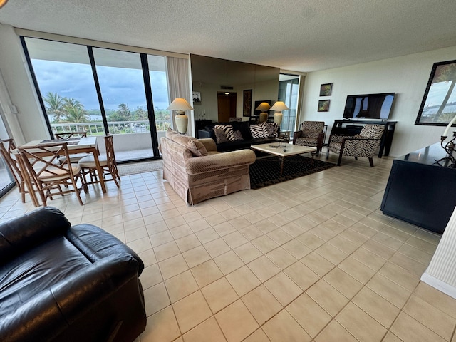 living room featuring a textured ceiling, expansive windows, and light tile patterned flooring