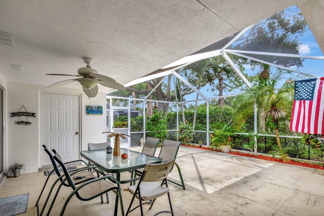 view of patio featuring ceiling fan and a lanai