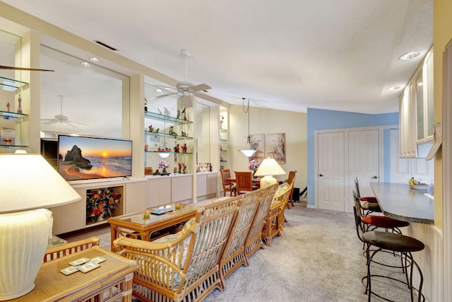 carpeted living room featuring ceiling fan and vaulted ceiling